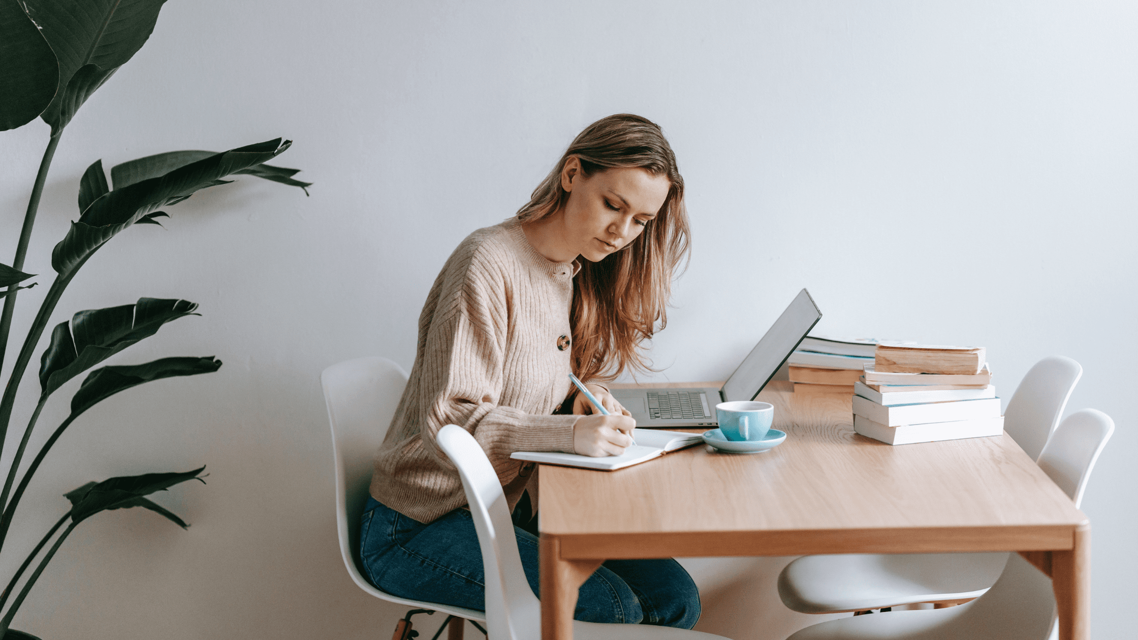 Medical student preparing for the USMLE Step 2 exam, taking notes at a desk with a laptop and study materials, representing focused study and exam preparation.